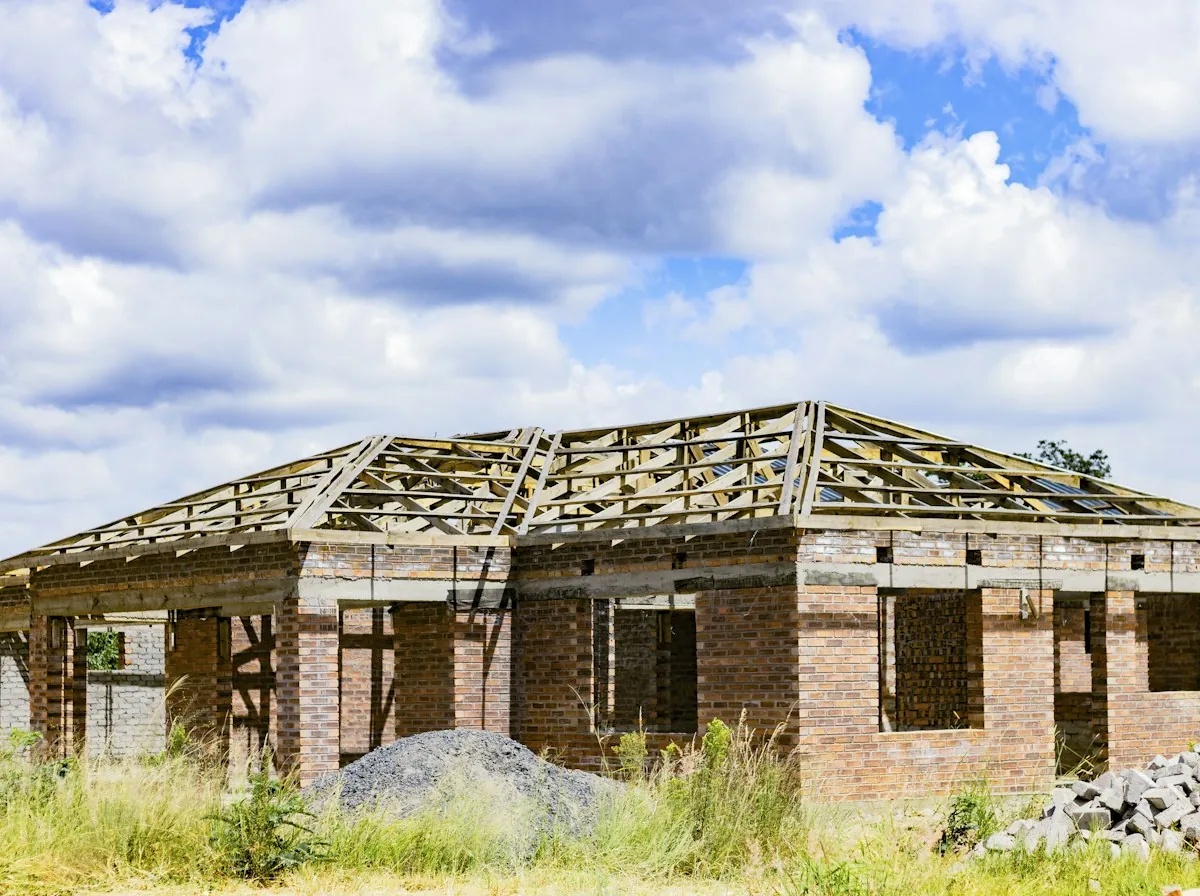 Roof Replacement in La Porte — new roof trusses on a brick house under construction